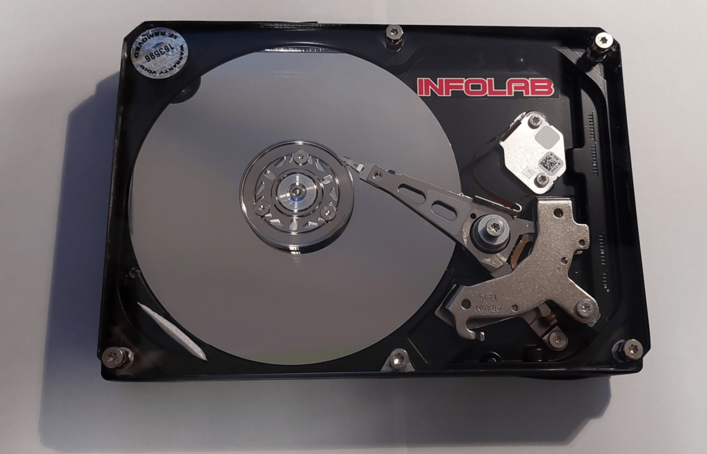IT stručnjak detaljno pregledava tvrdi disk koji se nalazi na stolu.