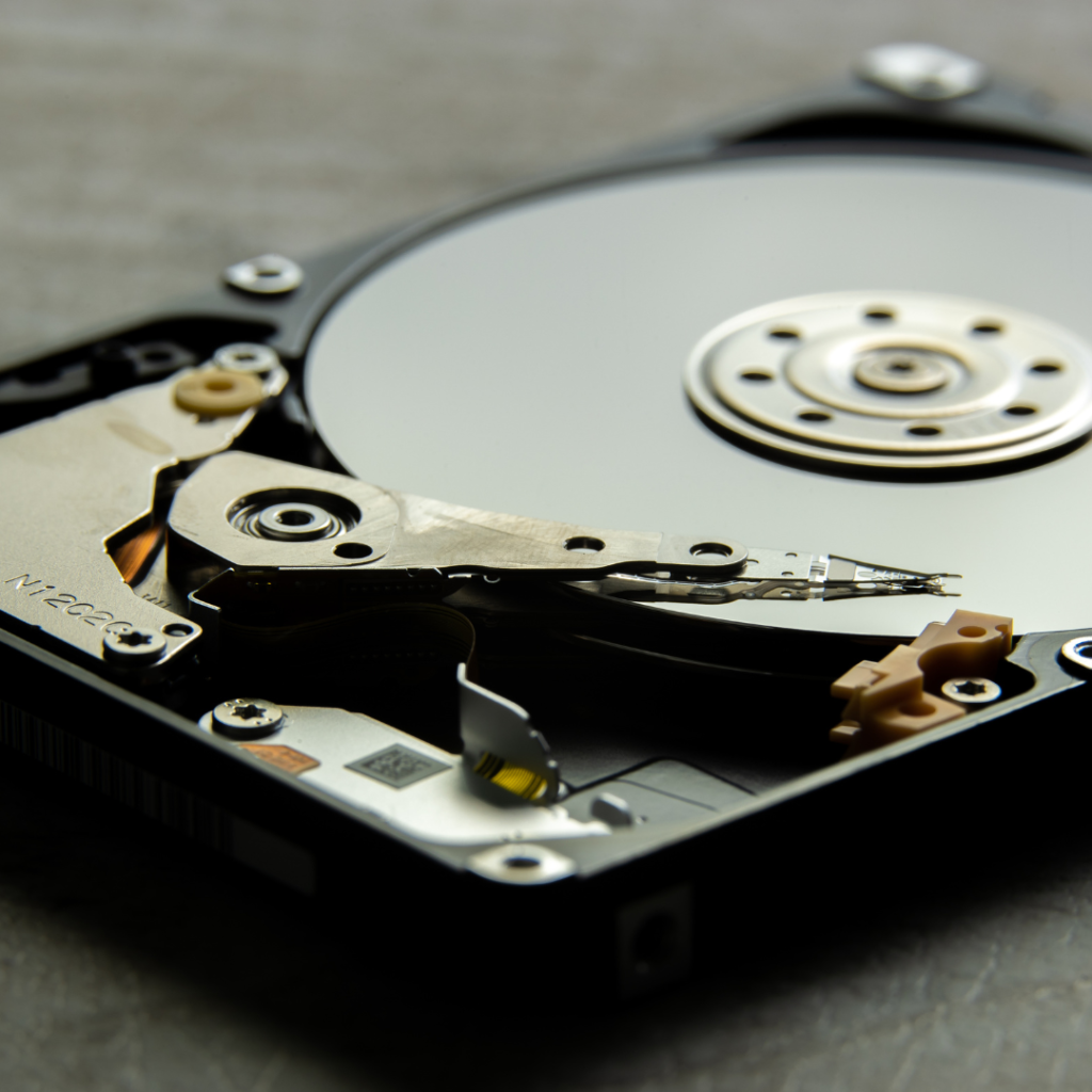 Tehničar detaljno pregledava otvoreni tvrdi disk na radnom stolu.
