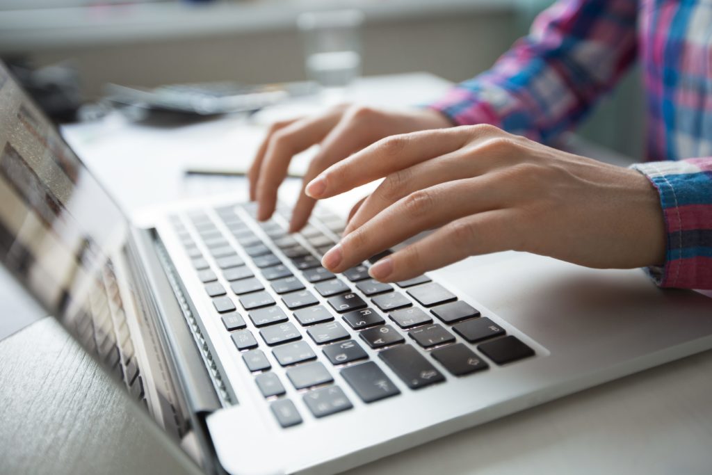 Serviser pažljivo pregledava oštećeni tvrdi disk iz laptopa.
